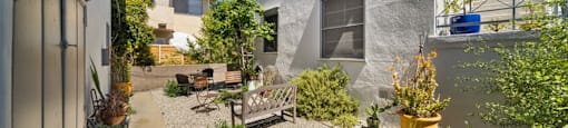 a courtyard between two buildings with a bench and plants
