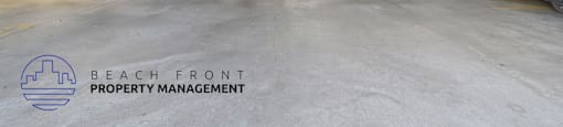 A parking garage with several cars parked and the logo of Beach Front Property Management on the ground.