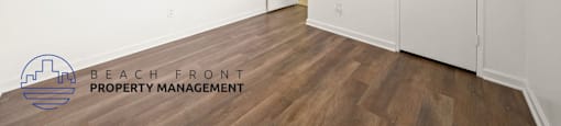 A room with a ceiling fan and wooden flooring.