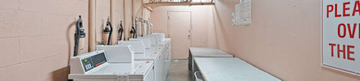 a laundry room with several washes and dryers in it