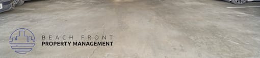 A parking garage with several cars and the logo of Beach Front Property Management.