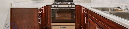 A kitchen with wooden cabinets and a stove top oven.