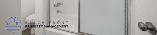 A glass shower door in a white bathroom.