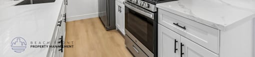 A kitchen with white cabinets and appliances.