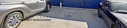 A silver car is parked in front of a blue garage door.