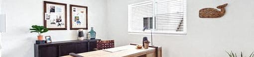 A room with a wooden table and a rug in front of it.