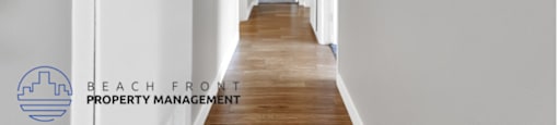 a renovated hallway with white walls and wood floors and a light on the ceiling