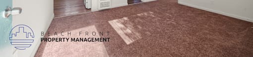 A room with a carpeted floor and a logo for Beach Front Property Management.