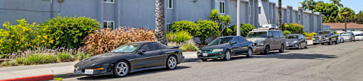 a row of cars parked on a street in front of a building