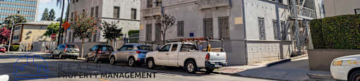 an old building on the corner of a street with parked cars