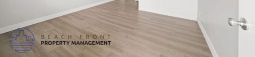 A room with a door and a logo for Beach Front Property Management.