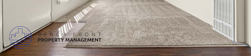 A spacious room with a rug on the floor and a door on the left.