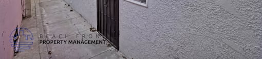A white building with a black door and window.