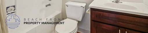 A bathroom with a toilet, sink, and mirror.