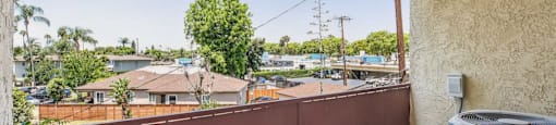 A balcony with a view of the street and houses, managed by Beach Front Property Management.