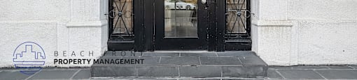 The front door of a building with a sign that says "BEACH FRONT PROPERTY MANAGEMENT".