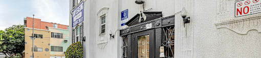 A building with a black door and a sign that says "NO" on the wall.