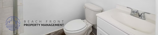A white toilet sits next to a sink in a bathroom.