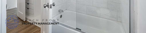 A bathroom with a walk-in shower and a white door.