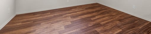 A room with a ceiling fan and wooden flooring.