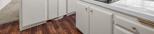 A white kitchen with a stove top oven and a microwave.