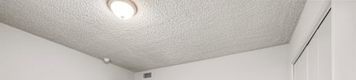 A room with white walls and a grey carpet.