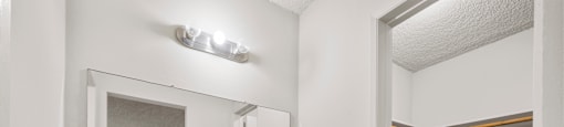 A white vanity with a mirror and drawers is in a room.