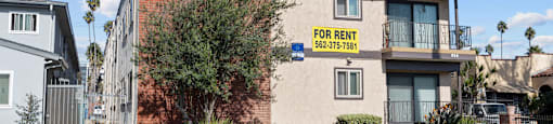 A house with a "FOR RENT" sign in front of it.