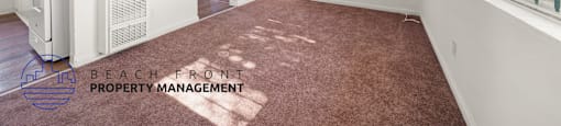 A room with a carpeted floor and a window with a view of the outside.
