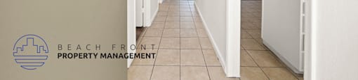 A long hallway with a logo for Beach Front Property Management in the bottom left corner.