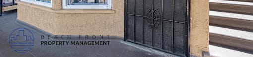 A black gate with a number 144 on it is on the right side of a house.