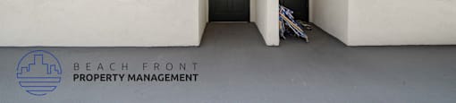 A white building with a sign that says Beach Front Property Management.