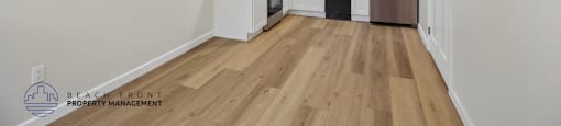 A kitchen with white cabinets and a wooden floor.