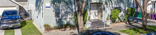 A blue car is parked in front of a house.