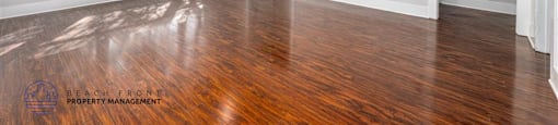 A spacious room with wooden floors and a ceiling fan.