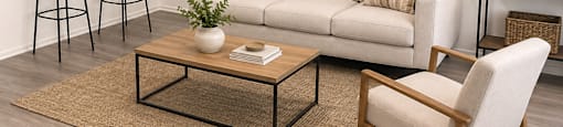 A living room with a white couch, a coffee table, and a chair.