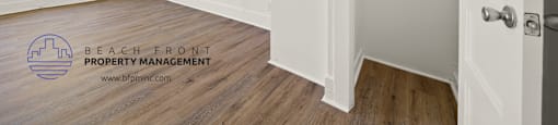 a bedroom with hardwood floors and white walls