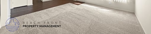 A spacious room with a carpeted floor and a ceiling fan.