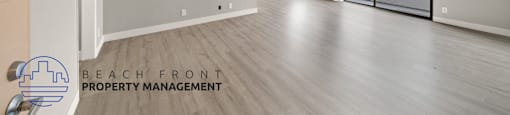 the living room and dining room of an apartment with wood flooring and a balcony