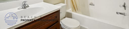 A bathroom with a white sink and a white toilet.