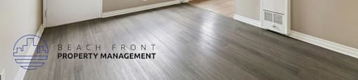 an empty living room with wood flooring and white walls