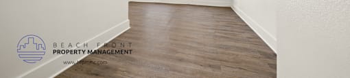 a bedroom with hardwood flooring and white walls