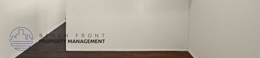 A room with a ceiling fan and a logo for Beach Front Property Management.