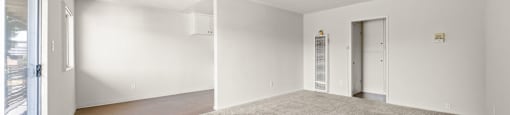 A spacious room with a carpeted floor and white walls.