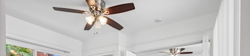 A spacious room with a ceiling fan and wooden flooring.