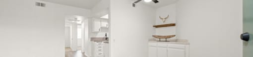 A room with a ceiling fan and wood flooring.