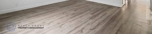 A room with wooden flooring and white walls.