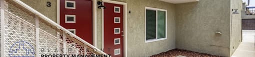 a balcony of a building with red doors and a staircase