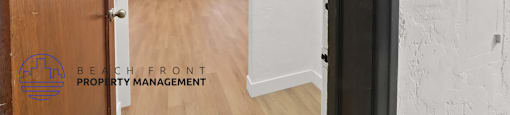 A hallway with a door numbered 107 and a logo for Beachfront Property Management.