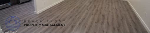 an image of a hallway with wood flooring and white walls